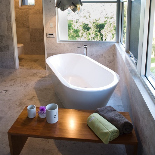 Large format tiles in modern luxury bathroom with freestanding bath