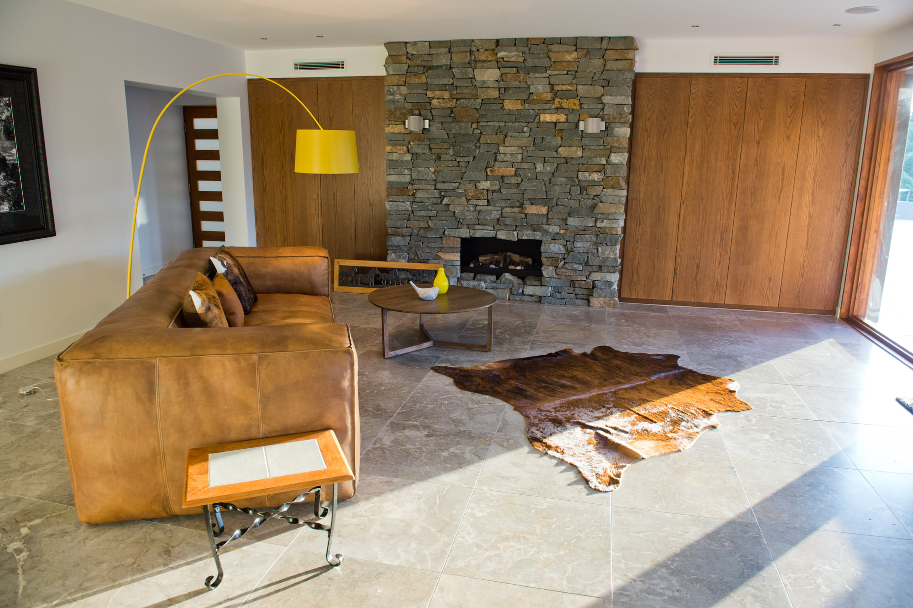 Beautiful natural stone floor ti,es in living room space with large fire.